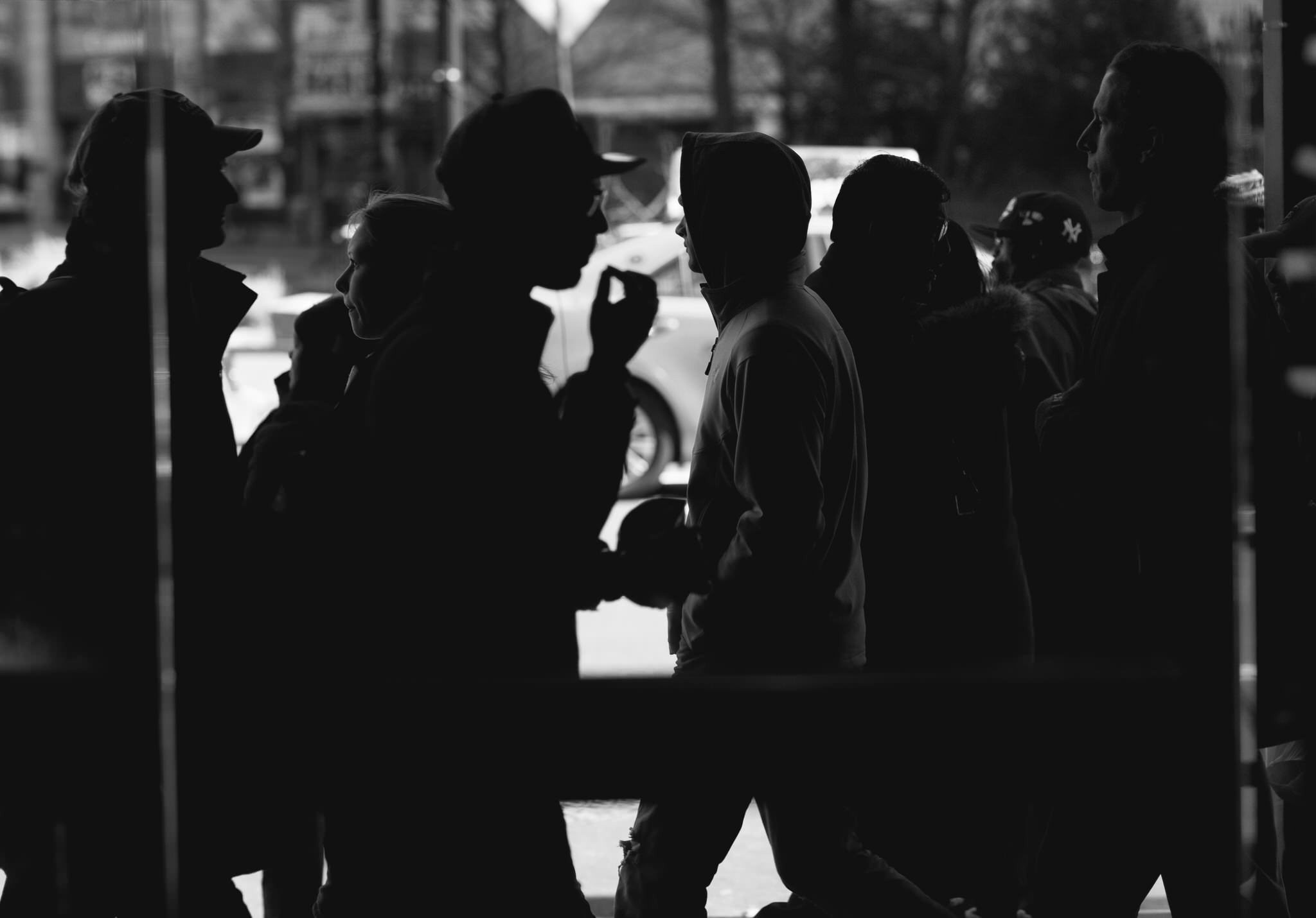 A lone figure held still amid the blur of a moving crowd